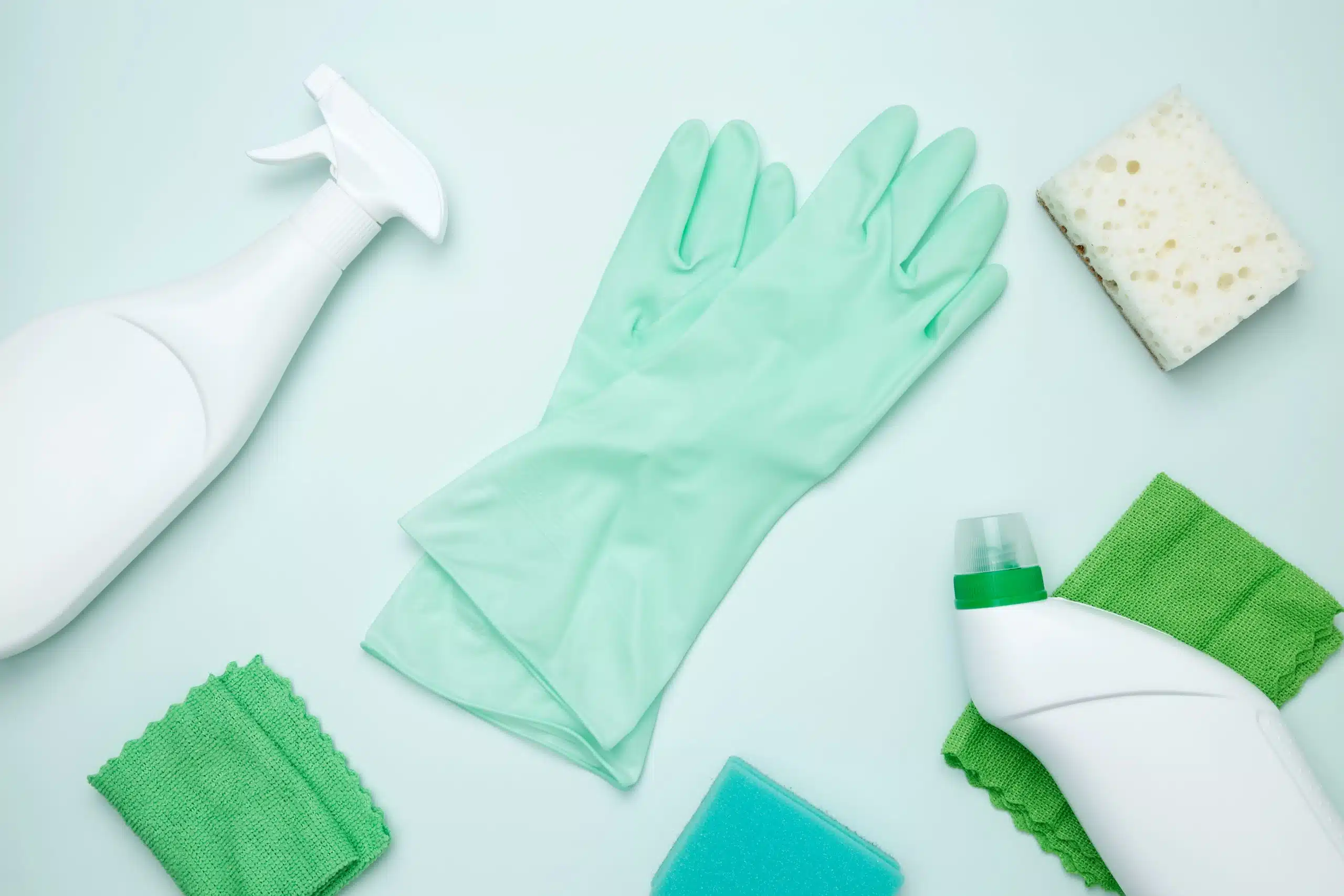 Cleaning supplies and tools, including bottles, gloves, sponges, and cloths. Concept of cleanliness and hygiene